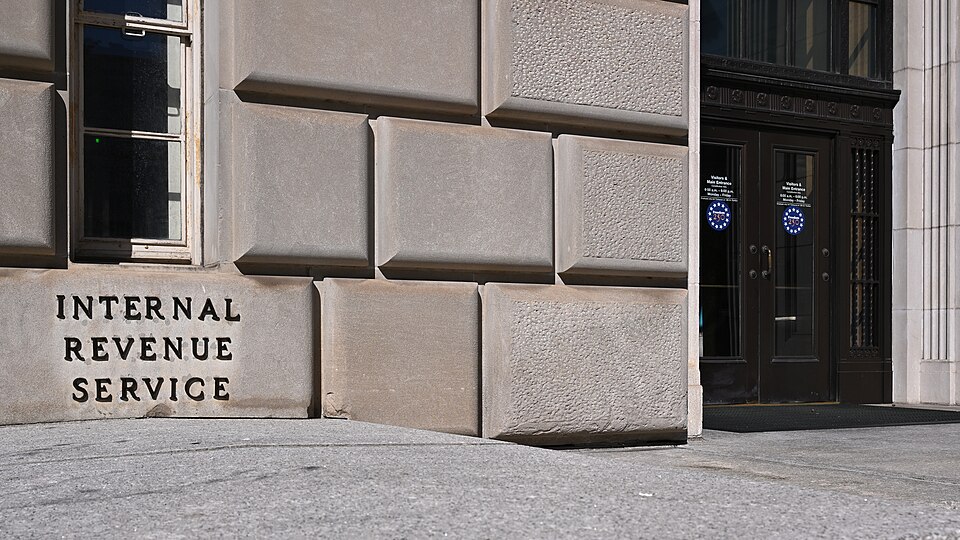 Internal Revenue Service lettering on a stone wall beside a dark double-door entrance.